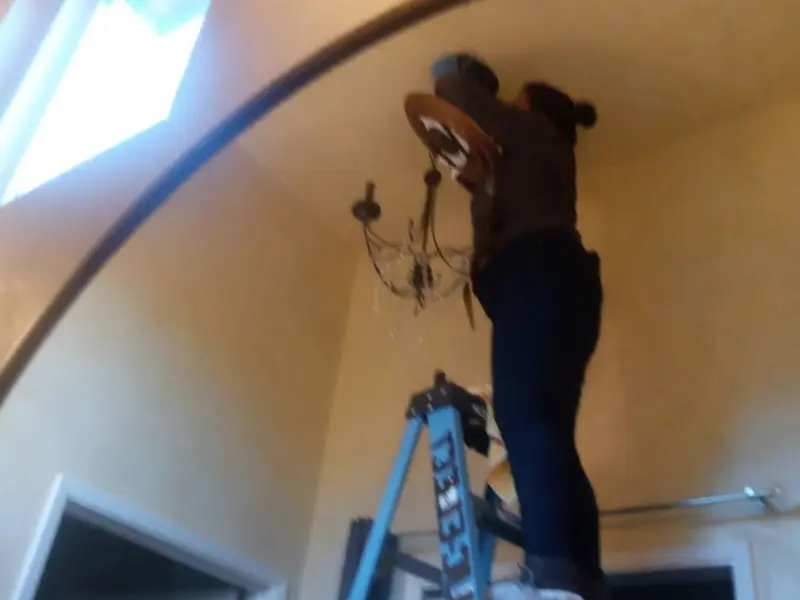 Electrician installing a chandelier in a Dade City North residence